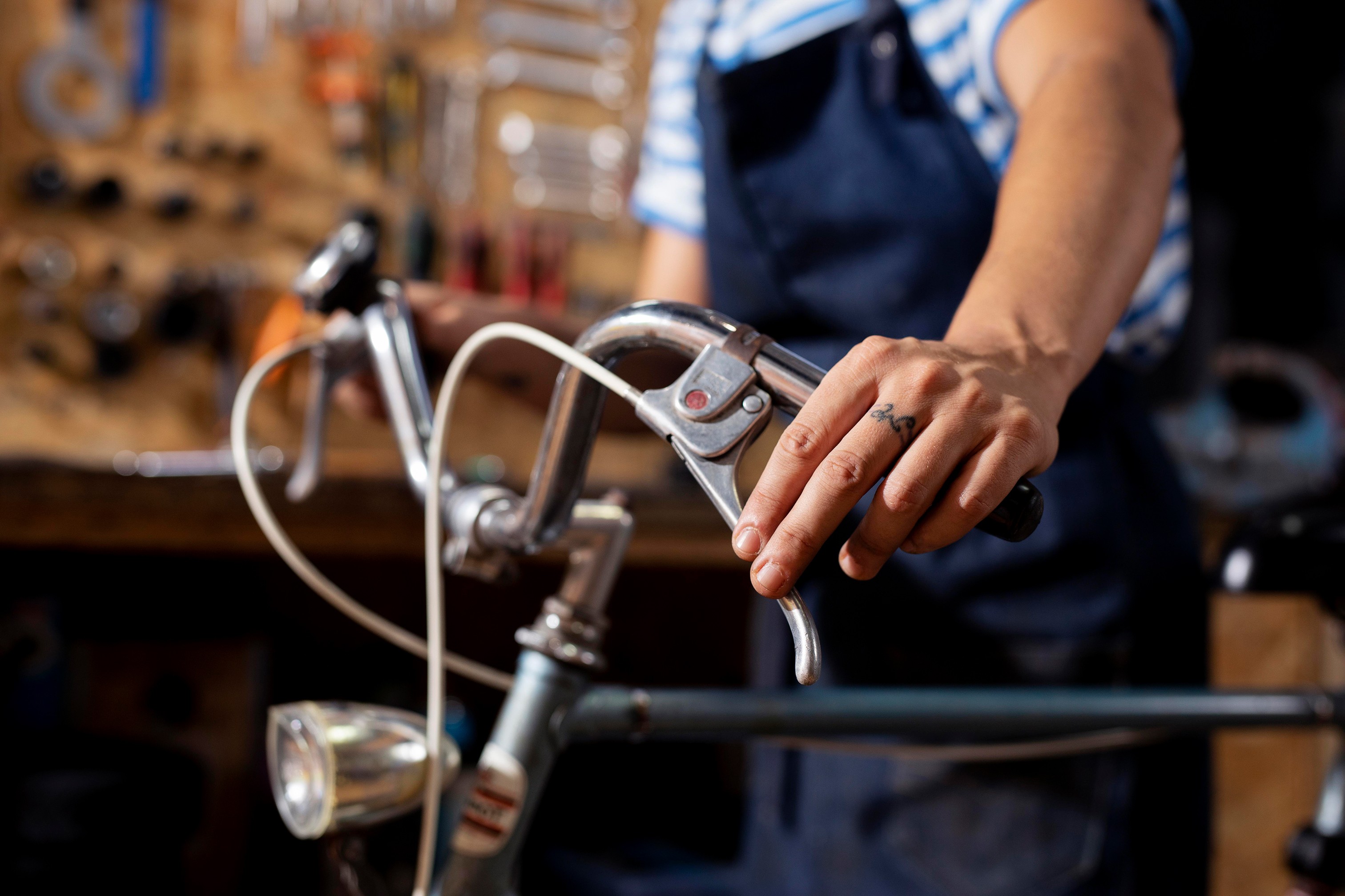 Hand greift am Lenker eines Fahrrads in einer Werkstatt